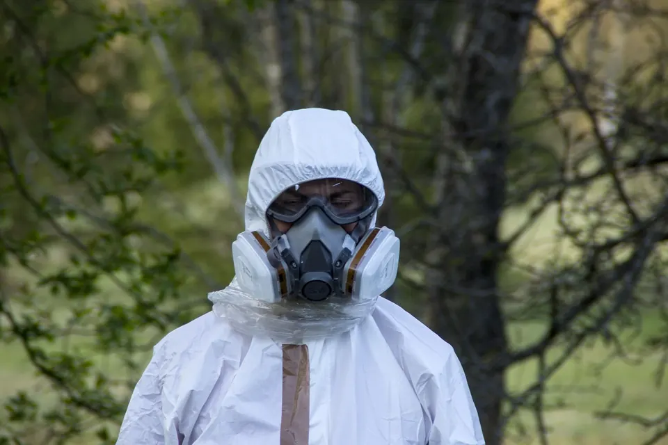 Person in Schutzanzug mit Atemschutzmaske